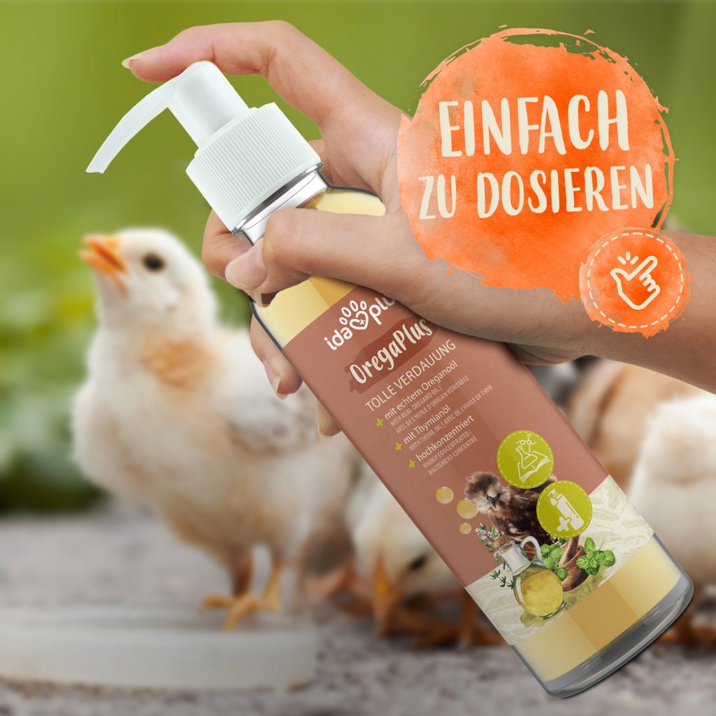 Ida Plus OregaPlus. Es ist ein Küken zu sehen, sowie unser Produkt für eine tolle Verdauung, das in einer Hand gehalten wird  Es ist einfach zu dosieren.
